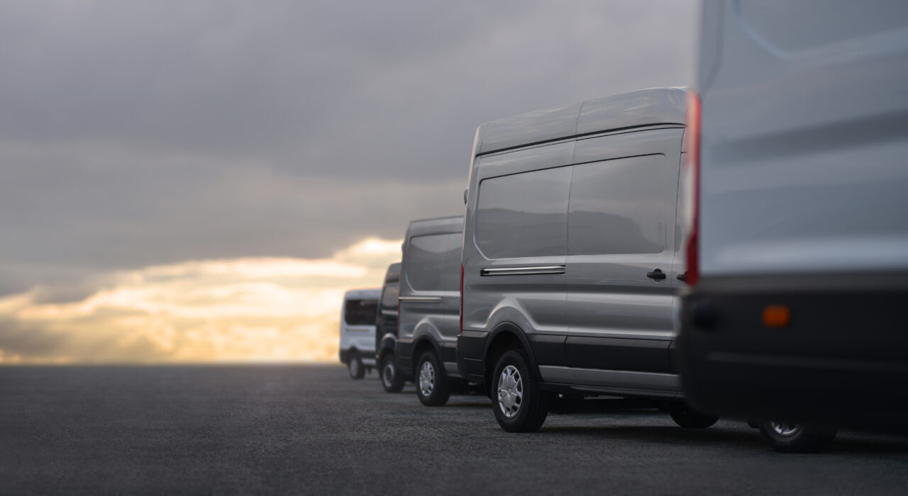 Commercial,Vans,In,Row,On,Dealership,Parking