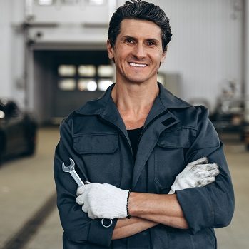 Car service, repair, maintenance and people concept. Waist up portrait view of the auto mechanic man or smith with wrench at workshop